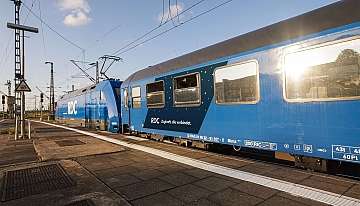 Ein blauer Nachtzug steht mit Lok und Liegewagen am Gleis.