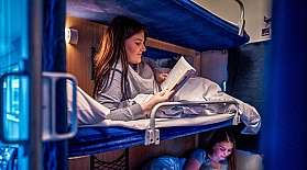 Zwei Frauen lesen in einem Liegewagen-Abteil im Nachtzug.