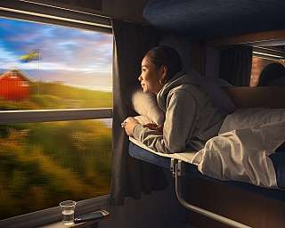 Eine Frau liegt im Liegewagen eines Nachtzugs auf dem Weg nach Schweden.